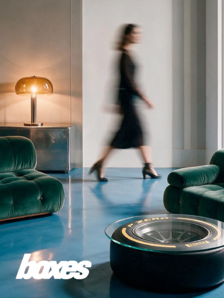 Interior del lounge Boxes en el Grand Prix Madrid, con sofás de terciopelo verde y mesa de neumático