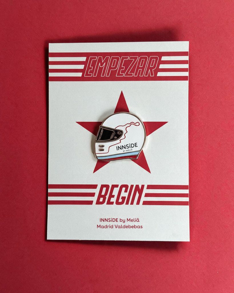 Tarjeta Empezar / Begin de la colección de pines para INNSiDE by Meliá Madrid Valdebebas, con el pin del casco sobre una estrella coral