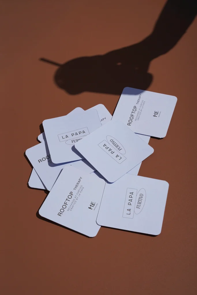 Posavasos de Rooftop Therapy apilados sobre una superficie marrón con sombra marcada — Barcelona