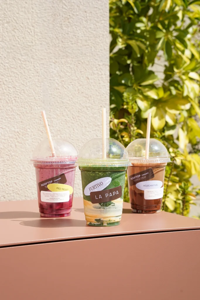 Tres bebidas de Rooftop Therapy alineadas en el rooftop Furtivo entre vegetación — Barcelona