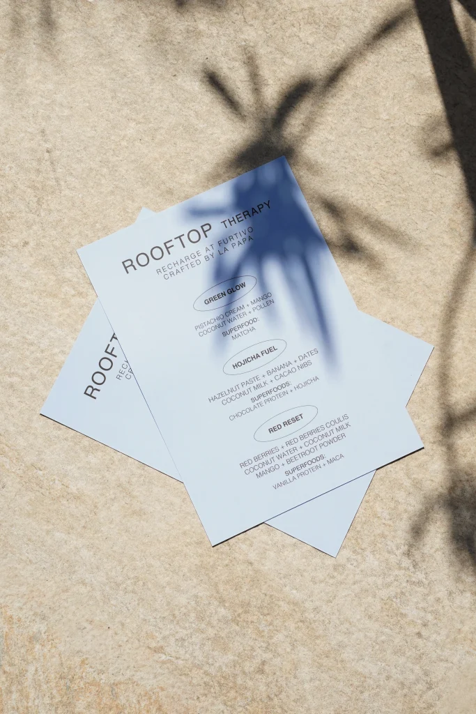 Posavasos de Rooftop Therapy sobre piedra clara con la sombra de una palmera
