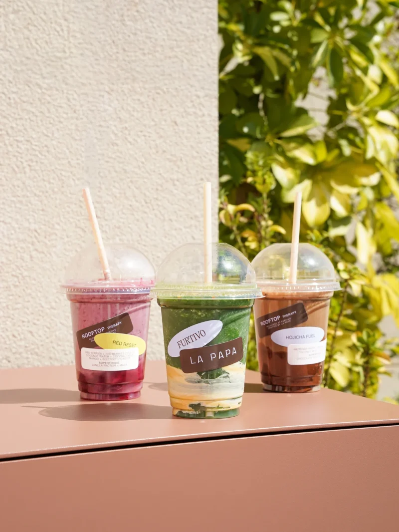 Tres bebidas de Rooftop Therapy alineadas en el rooftop Furtivo entre vegetación — Barcelona